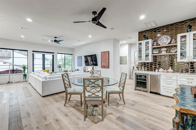 4622 Banning Dr, Houston, TX 77027 - dining area with wine cooler, ceiling fan, wet bar, light wood-type flooring, and recessed lighting