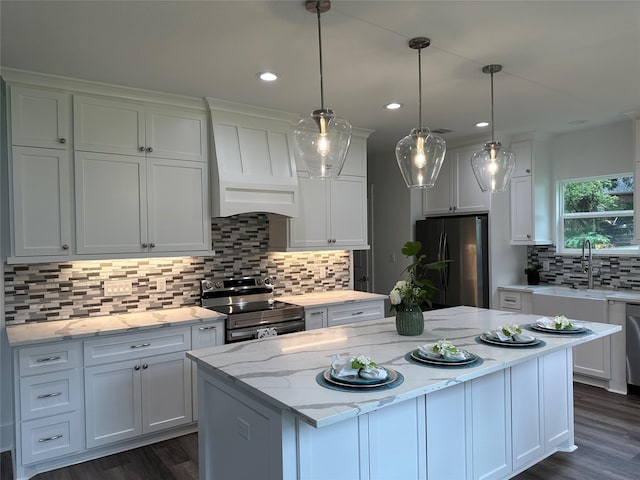 14159 Lakepoint Dr, Willis, TX 77318 - kitchen with stainless steel range with electric stovetop, freestanding refrigerator, custom range hood, white cabinetry, and recessed lighting