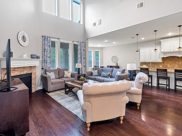 3314 Flint Valley Ln, Katy, TX 77494 - living area featuring dark wood-style floors, a high ceiling, a stone fireplace, and recessed lighting
