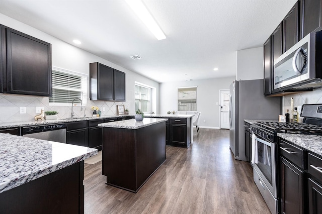 25130 Bells Canyon Dr, Porter, TX 77365 - kitchen with stainless steel appliances, dark wood-type flooring, backsplash, a center island, and recessed lighting