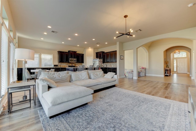 2407 Lost Bridge Ln, Pearland, TX 77584 - living area featuring arched walkways, a chandelier, light wood-style floors, and recessed lighting