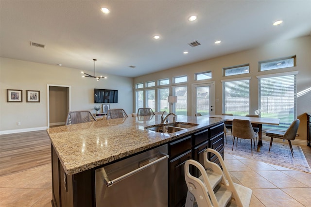 2407 Lost Bridge Ln, Pearland, TX 77584 - kitchen featuring stainless steel dishwasher, an island with sink, light tile patterned flooring, recessed lighting, and light stone countertops