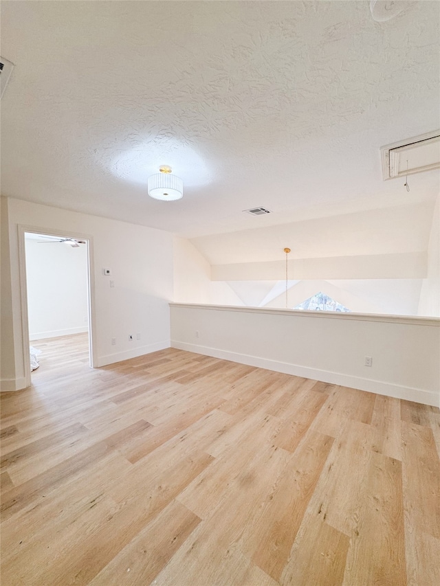2415 Jasmine Ridge Ct, Houston, TX 77062 - spare room featuring light wood finished floors, attic access, a textured ceiling, and lofted ceiling