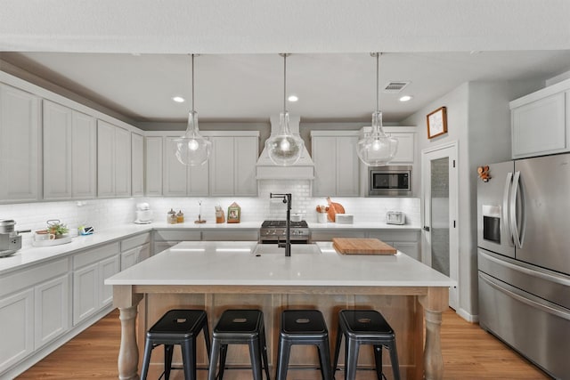 2307 Hagerman Rd, Conroe, TX 77384 - kitchen featuring stainless steel appliances, custom exhaust hood, light countertops, a kitchen breakfast bar, and recessed lighting
