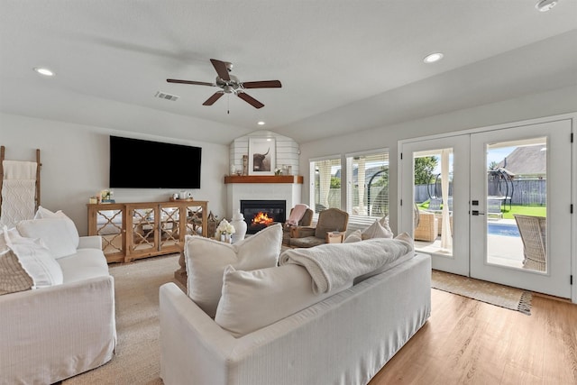 2307 Hagerman Rd, Conroe, TX 77384 - living area featuring french doors, a large fireplace, ceiling fan, light wood-style floors, and vaulted ceiling