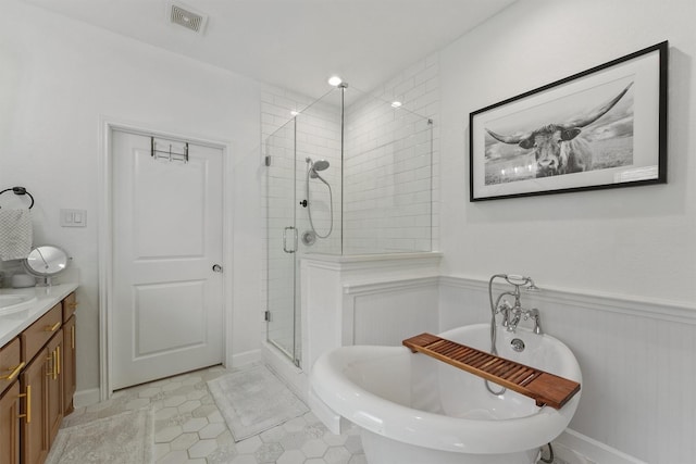 2307 Hagerman Rd, Conroe, TX 77384 - full bath featuring a stall shower, a freestanding tub, a wainscoted wall, vanity, and tile patterned floors