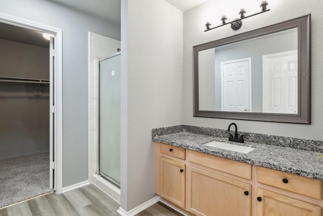 5911 Drenner Park Ln, Houston, TX 77086 - full bath featuring wood finished floors, a shower stall, a spacious closet, and vanity