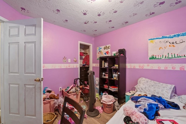 16145 Sun View Ln, Conroe, TX 77302 - bedroom featuring wood finished floors and a textured ceiling