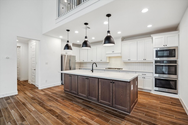 17471 Bayflower, Conroe, TX 77385 - kitchen featuring appliances with stainless steel finishes, light countertops, white cabinetry, dark wood finished floors, and recessed lighting