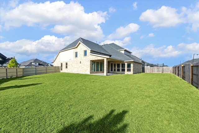 17471 Bayflower, Conroe, TX 77385 - back of house featuring a fenced backyard, stone siding, brick siding, and roof with shingles