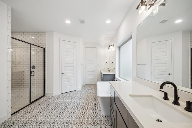 17471 Bayflower, Conroe, TX 77385 - bathroom featuring a stall shower, two vanities, a freestanding bath, and recessed lighting