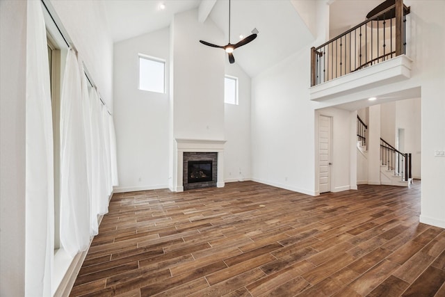 17471 Bayflower, Conroe, TX 77385 - unfurnished living room featuring high vaulted ceiling, ceiling fan, stairway, wood finished floors, and a fireplace