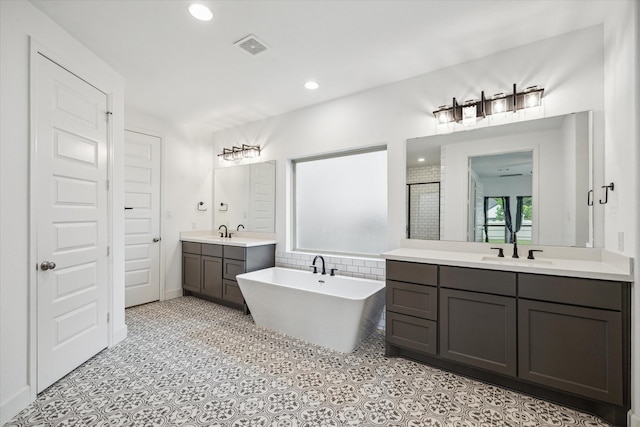 17471 Bayflower, Conroe, TX 77385 - full bathroom with two vanities, a freestanding bath, recessed lighting, and a shower