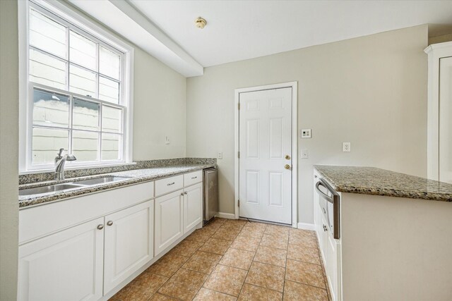 2127 Milford St, Houston, TX 77098 - kitchen featuring a warming drawer, white cabinetry, light stone counters, and stainless steel dishwasher