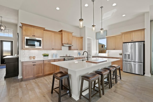 2234 Elm Rdg, Tomball, TX 77375 - kitchen with stainless steel appliances, under cabinet range hood, light countertops, a breakfast bar area, and recessed lighting