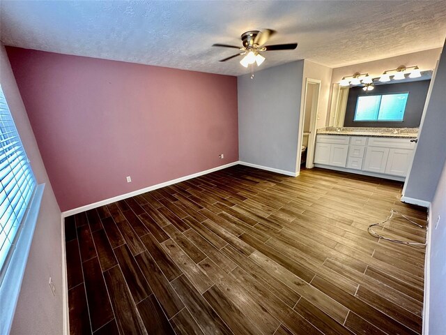 7254 Sonnet Glen Ln, Houston, TX 77095 - unfurnished bedroom featuring wood finished floors, a textured ceiling, connected bathroom, and a ceiling fan