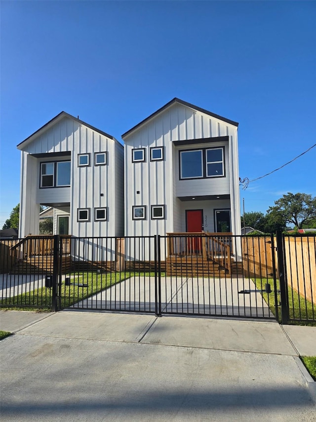3210 Retta St A-B, Unit A-B Houston, TX 77026 - view of front facade with board and batten siding, a fenced front yard, and a gate