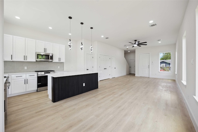3210 Retta St A-B, Unit A-B Houston, TX 77026 - kitchen featuring stainless steel appliances, light wood-style floors, a kitchen island, white cabinetry, and decorative backsplash