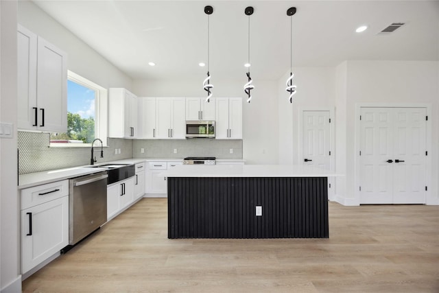 3210 Retta St A-B, Unit A-B Houston, TX 77026 - kitchen featuring appliances with stainless steel finishes, a center island, light countertops, white cabinetry, and recessed lighting