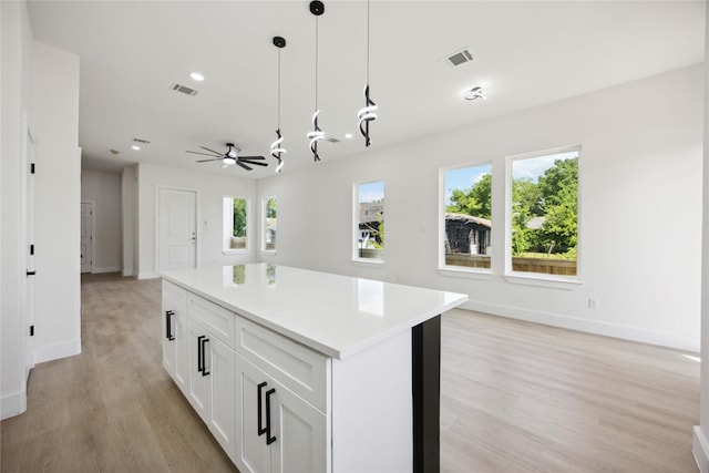 3210 Retta St A-B, Unit A-B Houston, TX 77026 - kitchen with light wood finished floors, white cabinetry, hanging light fixtures, a kitchen island, and light countertops