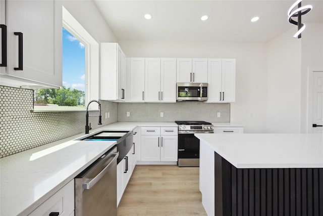 3210 Retta St A-B, Unit A-B Houston, TX 77026 - kitchen featuring appliances with stainless steel finishes, white cabinetry, light wood-style flooring, decorative backsplash, and recessed lighting