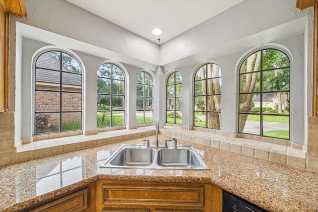 4331 Haven Glen Dr, Houston, TX 77339 - kitchen featuring brown cabinetry, decorative backsplash, dishwashing machine, and light stone countertops