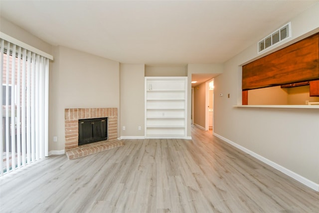12905 Woodforest Blvd Unit 202, Houston, TX 77015 - unfurnished living room featuring wood finished floors and a brick fireplace