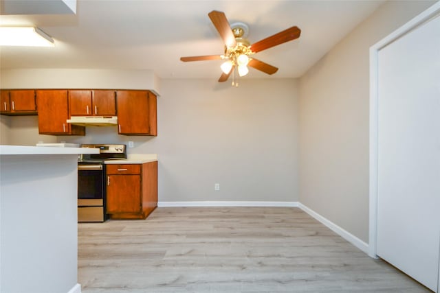 12905 Woodforest Blvd Unit 202, Houston, TX 77015 - kitchen with electric stove, under cabinet range hood, brown cabinets, a ceiling fan, and light countertops