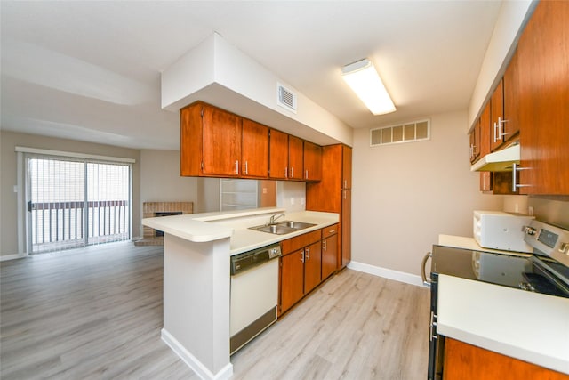 12905 Woodforest Blvd Unit 202, Houston, TX 77015 - kitchen with white appliances, brown cabinets, light wood-style flooring, and a peninsula