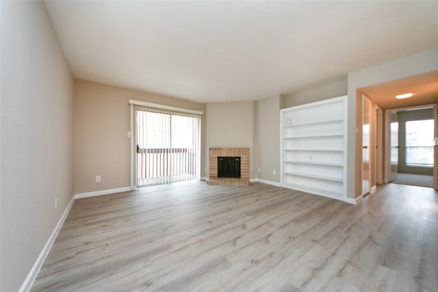 12905 Woodforest Blvd Unit 202, Houston, TX 77015 - unfurnished living room featuring light wood-style flooring, built in features, and a fireplace