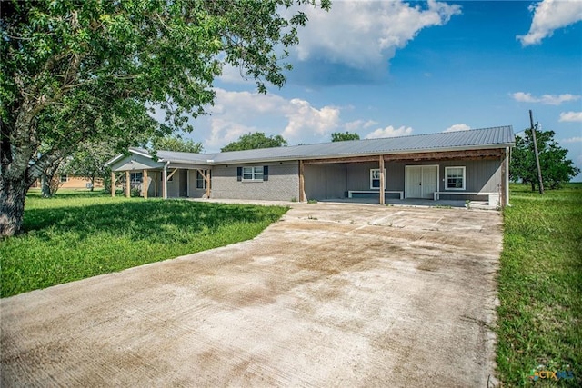 248 Park Rd, Port Lavaca, TX 77979 - ranch-style house with concrete driveway, a front yard, an attached carport, a metal roof, and covered porch