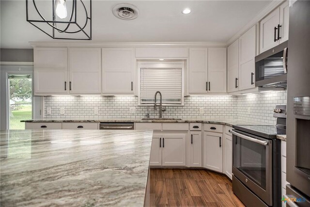 248 Park Rd, Port Lavaca, TX 77979 - kitchen featuring appliances with stainless steel finishes, white cabinets, dark wood finished floors, backsplash, and recessed lighting