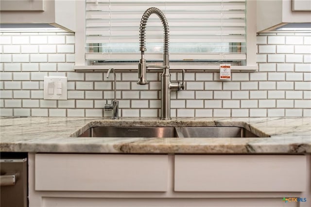 248 Park Rd, Port Lavaca, TX 77979 - kitchen view of tasteful backsplash, white cabinets, and light stone countertops