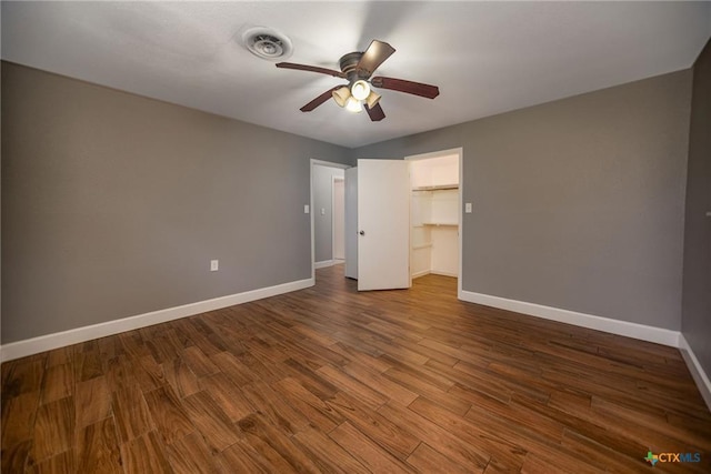 248 Park Rd, Port Lavaca, TX 77979 - unfurnished bedroom with dark wood-style flooring, a ceiling fan, a closet, and a spacious closet