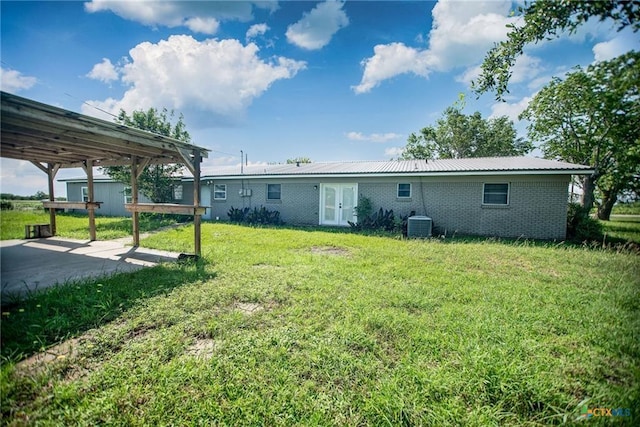 248 Park Rd, Port Lavaca, TX 77979 - rear view of house featuring brick siding, a lawn, french doors, a patio area, and a metal roof