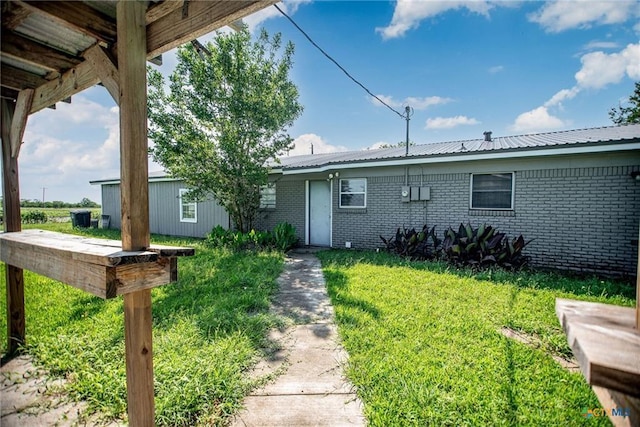 248 Park Rd, Port Lavaca, TX 77979 - view of front of home with brick siding, a front yard, and a metal roof