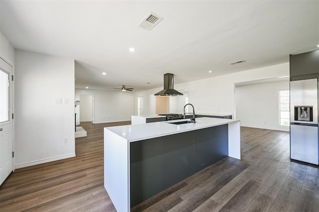 52 Oyster Creek Ct, Lake Jackson, TX 77566 - kitchen with a center island with sink, stainless steel fridge with ice dispenser, ventilation hood, light countertops, and dark wood-style flooring