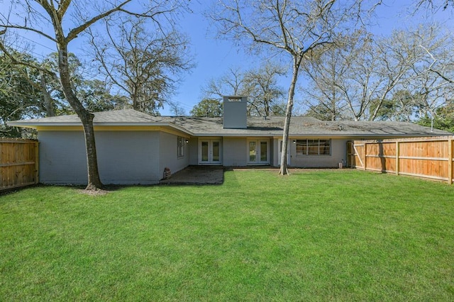 52 Oyster Creek Ct, Lake Jackson, TX 77566 - back of house featuring french doors, a fenced backyard, and a chimney