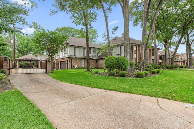 8706 Ashridge Park Dr, Spring, TX 77379 - view of front of house with a gate, brick siding, a front yard, and concrete driveway