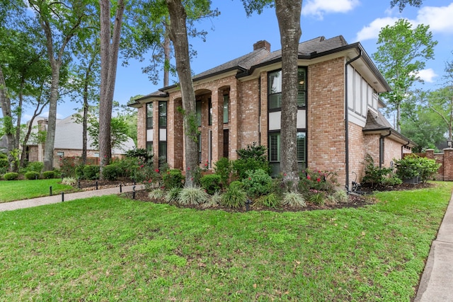 8706 Ashridge Park Dr, Spring, TX 77379 - view of front of home with brick siding, a front lawn, and a chimney