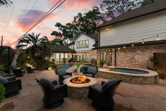 8706 Ashridge Park Dr, Spring, TX 77379 - patio terrace at dusk featuring an in-ground hot tub, a patio, an outdoor pool, and an outdoor fire pit