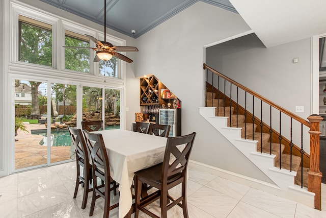 8706 Ashridge Park Dr, Spring, TX 77379 - dining space featuring a ceiling fan, a high ceiling, stairway, light marble finish floors, and crown molding