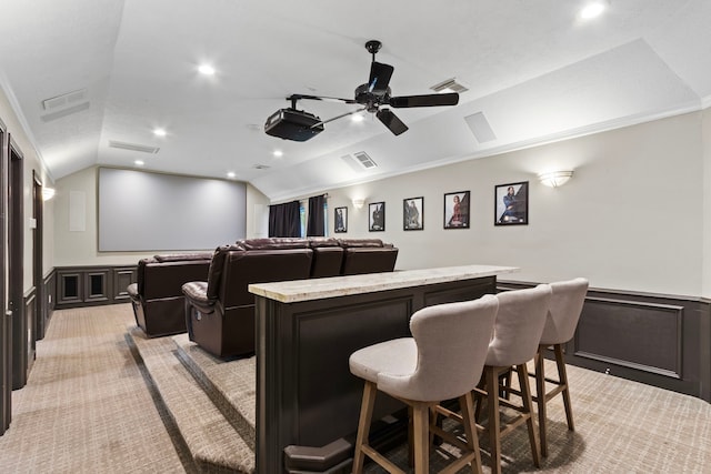8706 Ashridge Park Dr, Spring, TX 77379 - home theater room with lofted ceiling, light carpet, a bar, a wainscoted wall, and a decorative wall