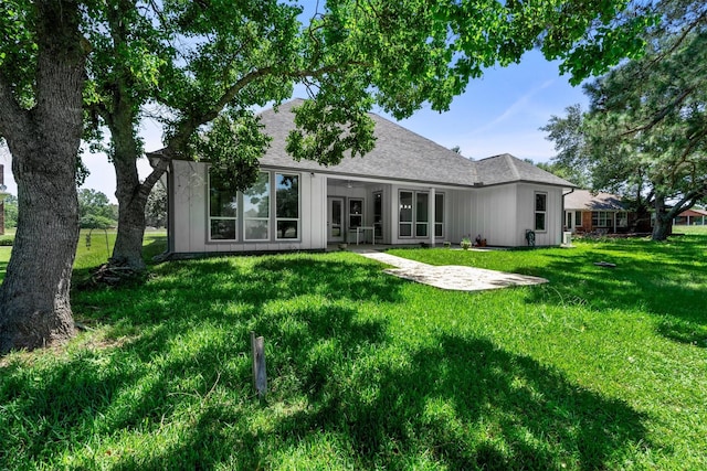 29 Westwood Dr W, Trinity, TX 75862 - back of house with a lawn, a shingled roof, and board and batten siding