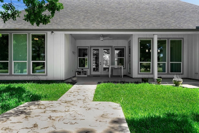 29 Westwood Dr W, Trinity, TX 75862 - view of exterior entry with roof with shingles, french doors, a ceiling fan, and a lawn