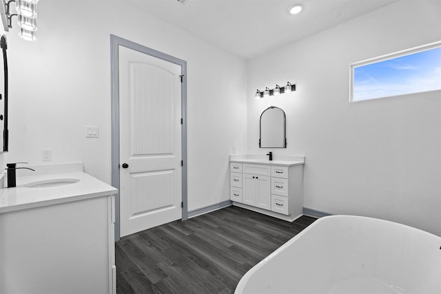 29 Westwood Dr W, Trinity, TX 75862 - full bath featuring two vanities, a soaking tub, wood finished floors, and recessed lighting