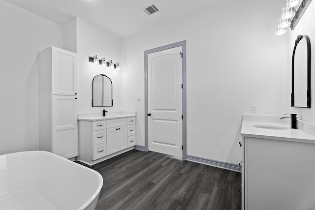 29 Westwood Dr W, Trinity, TX 75862 - bathroom featuring two vanities, wood finished floors, and a freestanding tub