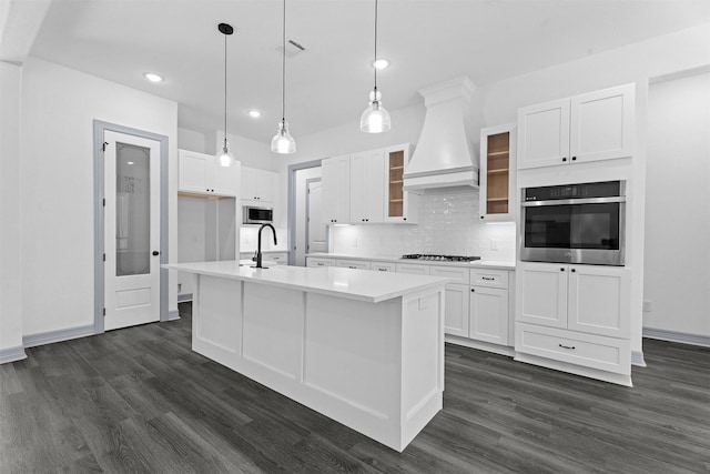 29 Westwood Dr W, Trinity, TX 75862 - kitchen featuring stainless steel appliances, wall chimney range hood, white cabinets, dark wood-type flooring, and recessed lighting