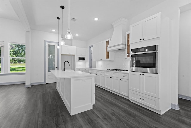 29 Westwood Dr W, Trinity, TX 75862 - kitchen featuring stainless steel appliances, dark wood-style flooring, custom range hood, light countertops, and recessed lighting