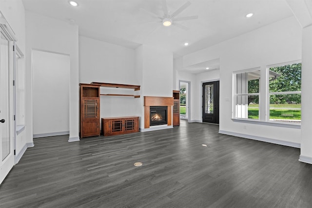 29 Westwood Dr W, Trinity, TX 75862 - unfurnished living room with ceiling fan, a warm lit fireplace, dark wood finished floors, and recessed lighting
